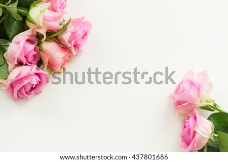 Styled desktop scene with pink fresh rose flowers, copy space on white table