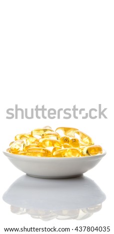 Fish oil supplement capsule in white bowl over white background
