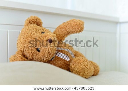 Lonely Teddy Bear lying on the bed. Concept about waiting for someone and loneliness. (Focus on bear's eye)