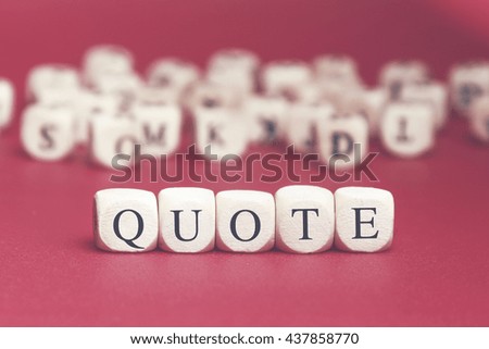 Quote word written on wood cube with red background