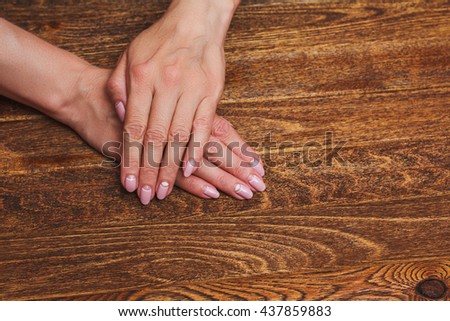 White and pink nail art on the wooden background