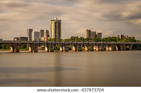 Sunset skyline of Tulsa, Oklahoma with Arkansas river in the foreground. Long exposure.