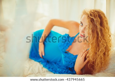 fragile pregnant woman in pajamas  posing for the photographer