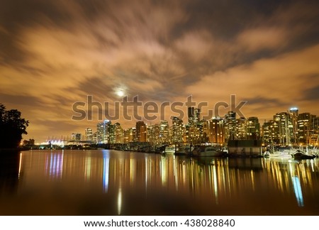 Moon Over Vancouver Night. The night skyline of downtown Vancouver, British Columbia, Canada, from Stanley Park. Evening as the the moon is rising.
                               