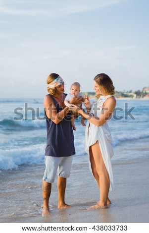 beautiful young couple in love with a child on the beach. couple with a kid in the sunset on the ocean. happy family with a baby.young family hippie hipsters.young mother with long hair holds a child.