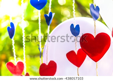 Bunch of handmade paper hearts hanging in the garden on Valentine's Day./ Bunch of paper hearts hanging.