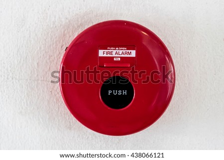 Red fire switch on white concrete wall