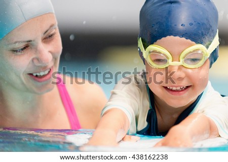 Happy little boy on swimming class with instructor