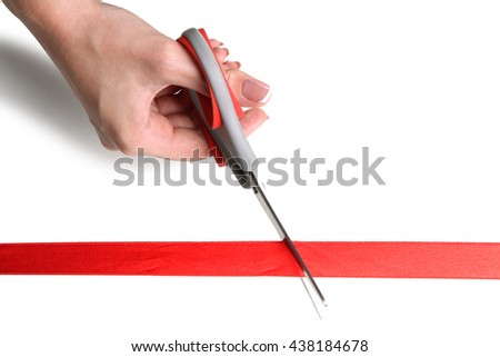 girl cuts red ribbon with scissors isolated on white background