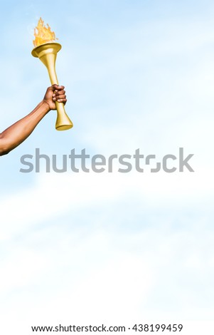 Front view of sportsman holding a cup against blue sky with clouds