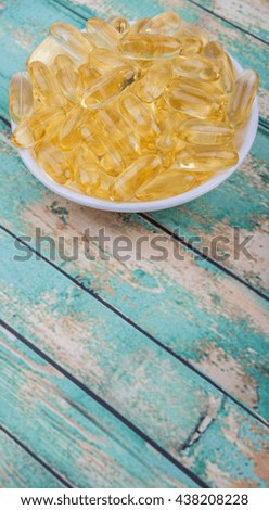Fish oil supplement capsule in white bowl over white background
