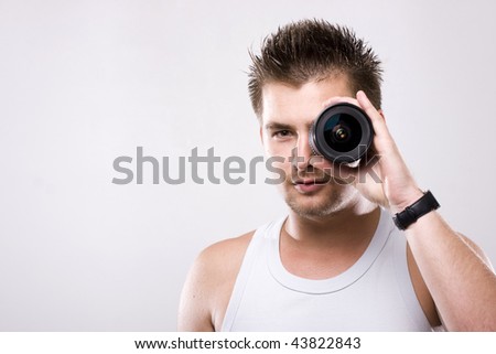 Young man looking throw camera lens at white background