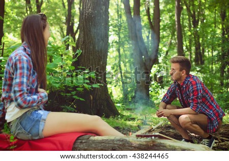 Happy young couple enjoy camping in forest. Portrait of a two young people talking.