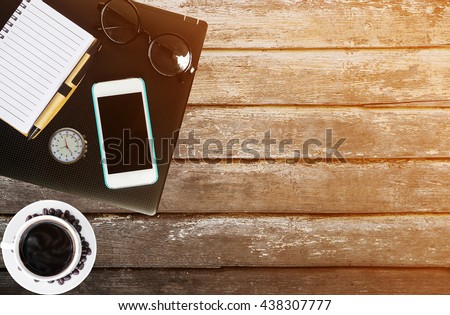 Cup coffee and hot coffee,laptop,watch,notebook,glasses,mobile-phone,on old wooden background,vintage tone filter style / copy space