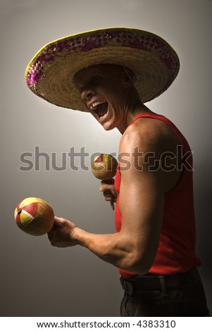 Portrait of a Mid-adult Caucasian male wearing sombrero holding maracas.