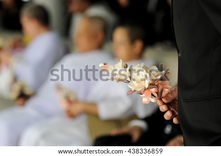 hand hold wood cremation flower, for funeral, background are Guests attending funeral Royalty-Free Stock Photo #438336859