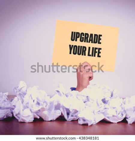 HAND HOLDING YELLOW PAPER WITH UPGRADE YOUR LIFECONCEPT