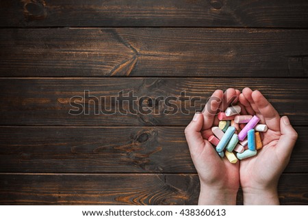 a lot of colorful pieces of chalk in the hands of a child