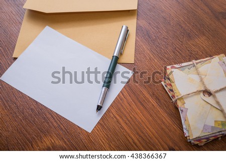 Bundle envelopes with pen and with paper wood table