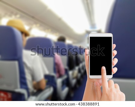 woman use mobile phone and blurred image of people in the airplane cabin