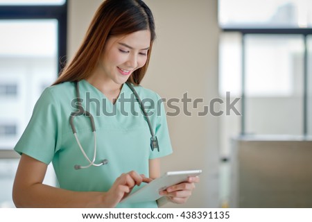 Young doctor woman smile face with stethoscope looking tablet computer. showing blank area for sign or copyspace