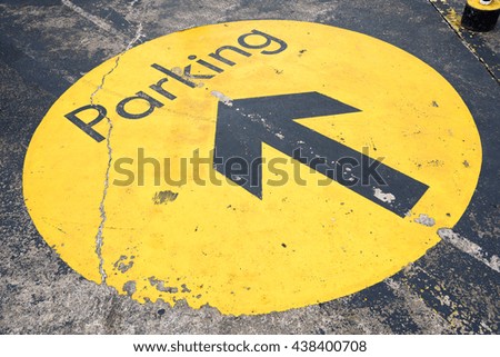 Parking sign on the ground with arrow for directions