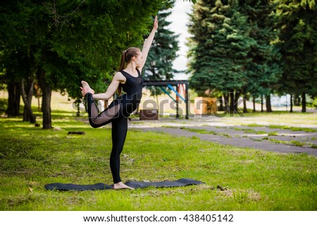 Balance exercise - young woman exercising in park