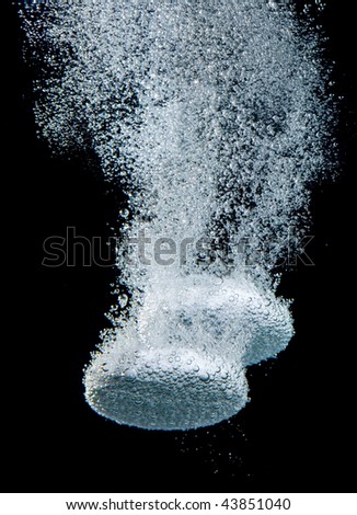 Effervescent tablet in water with bubbles...