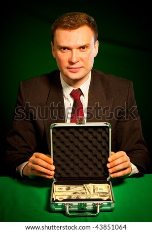 man's hand holds a suitcase with dollars...