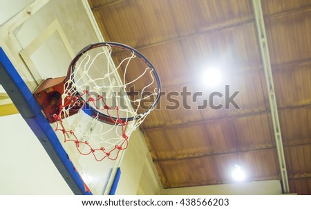 Low angle view of basketball hoop in an indoor arena with sport light on ceiling