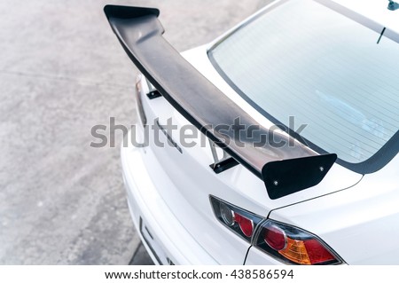 car part ; Close up detail of a custom racing carbon fiber spoiler on the rear of a modern car Royalty-Free Stock Photo #438586594