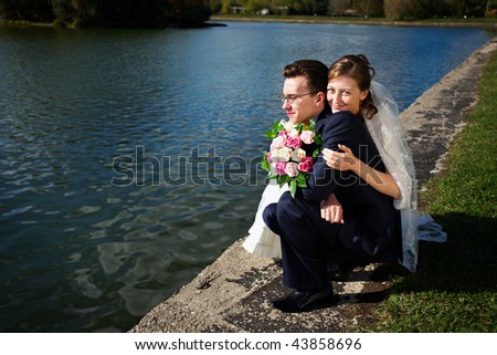Bride and groom on wedding walk near lake