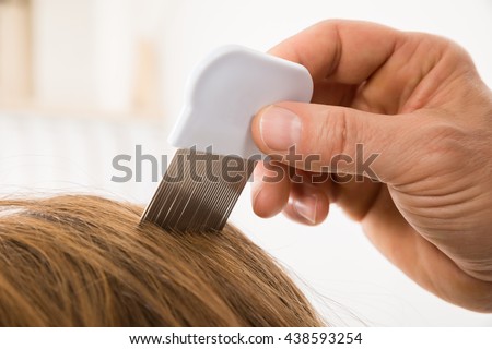 Close-up Of Person Hand Using Lice Comb On Patient's Hair