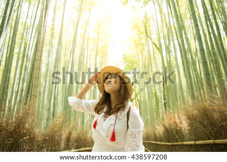 Asian woman is traveling into Bamboo forest in Kyoto.
