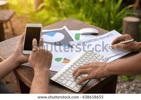 businessman using his laptop,stock chart,cellphone, close up