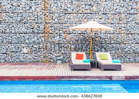 Umbrella and chair around swimming pool in beautiful luxury hotel resort for holiday vacation concept background