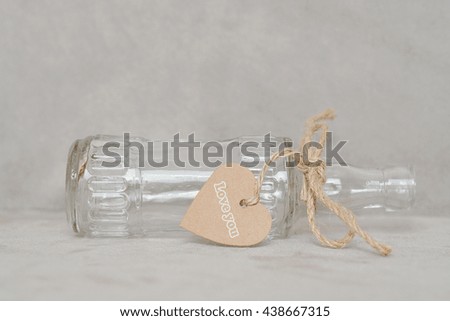 Empty bottle with heart shape tag and ribbon.  LOVE YOU word on tag
