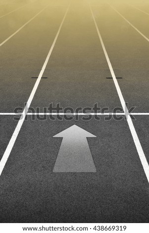 Dark Run Track at Stadium with Golden Light and Arrow