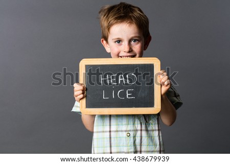 happy little child with red hair informing about head lice to fun fight against at school, grey background studio