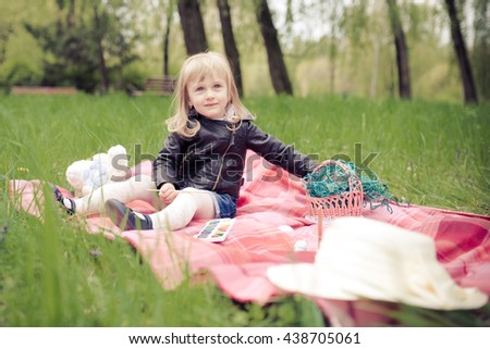 Little girl colorable Easter eggs in the park