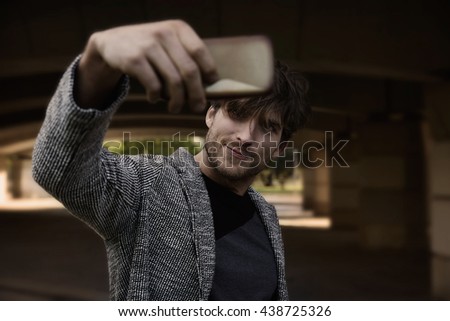 Modern young man smartphone taking selfie photos under a bridge