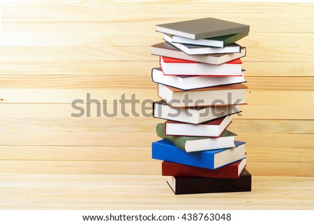 Stack of hardback books on wooden table. Back to school. Copy space.