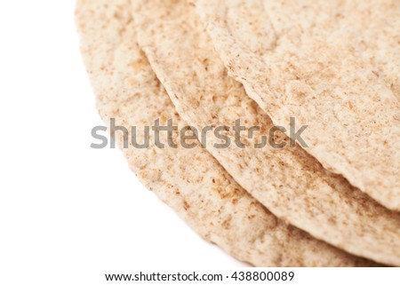 Pile of wheat tortillas isolated over the white background, close-up crop fragment as a copyspace backdrop composition