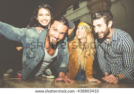 Group of friends sitting on the stairs and taking selfie. Having fun in the night outdoor Royalty-Free Stock Photo #438803410