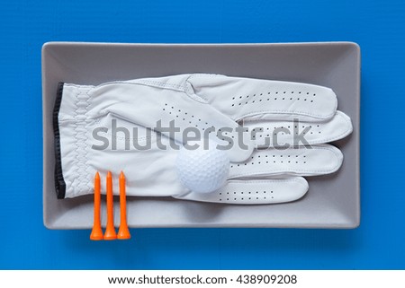 Gray ceramic dish with golf glove on over blue  background, rectangle dish