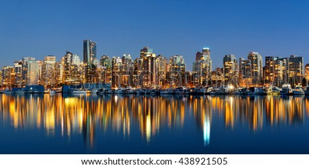 Vancouver downtown architecture and boat with water reflections at dusk panorama