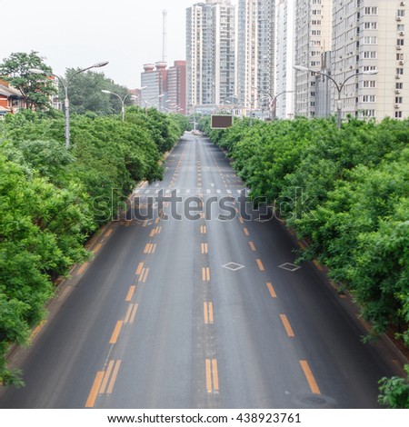 Road with a marking. The track on the background of the city and trees.