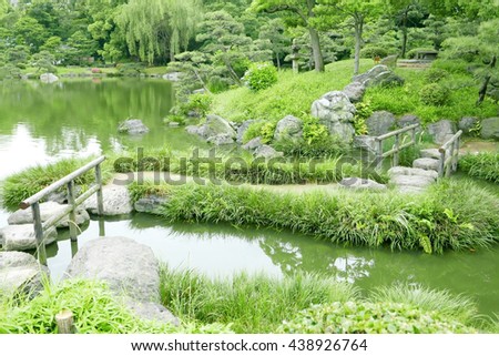 Stone bridge with wooden frames,water pond and green grasses