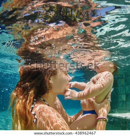 Funny happy family - mother, baby learn to swim and dive underwater with fun in pool. Healthy lifestyle, active parents, people water sports activity and swimming lessons on summer holidays with child