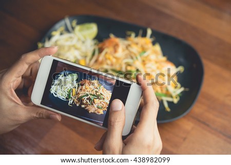 Woman hand taking Thai food photo by mobile phone. Food photography. Share food photography. Popular food photo.